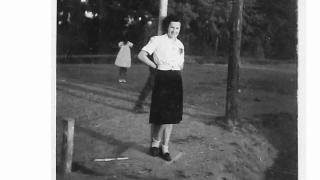 A black and white photograph of a lady with a shadow figure in the background.