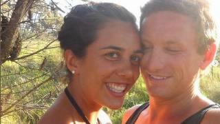 A man and woman taking a selfie on a hike.