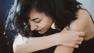 woman hugging in her knee looking down