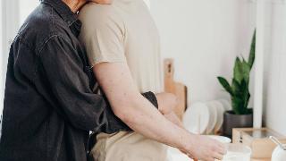 photo-of-woman-hugging-her-man from behind while he cooks