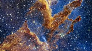 The Pillars of Creation are set off in a kaleidoscope of color in NASA's James Webb Space Telescope’s near-infrared-light view. The pillars look like arches and spires rising out of a desert landscape, but are filled with semi-transparent gas and dust, and ever changing. This is a region where young stars are forming – or have barely burst from their dusty cocoons as they continue to form.