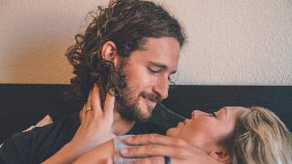 couple stare at each other affectionately on couch