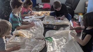 kids draw on sheets by chirstmas tree