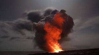 A large fire erupting on the landscape, huge billows of smoke in the air.