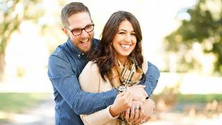 A man embracing his girlfriend from behind while they both laugh.