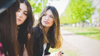 Three young female friends having conversation in park