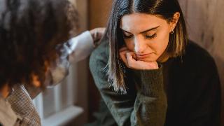 A sad woman being consoled by her friend. 