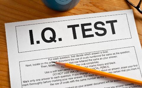 A paper IQ test on a table with a pencil on top.