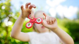 A kid playing with a fidget spinner.