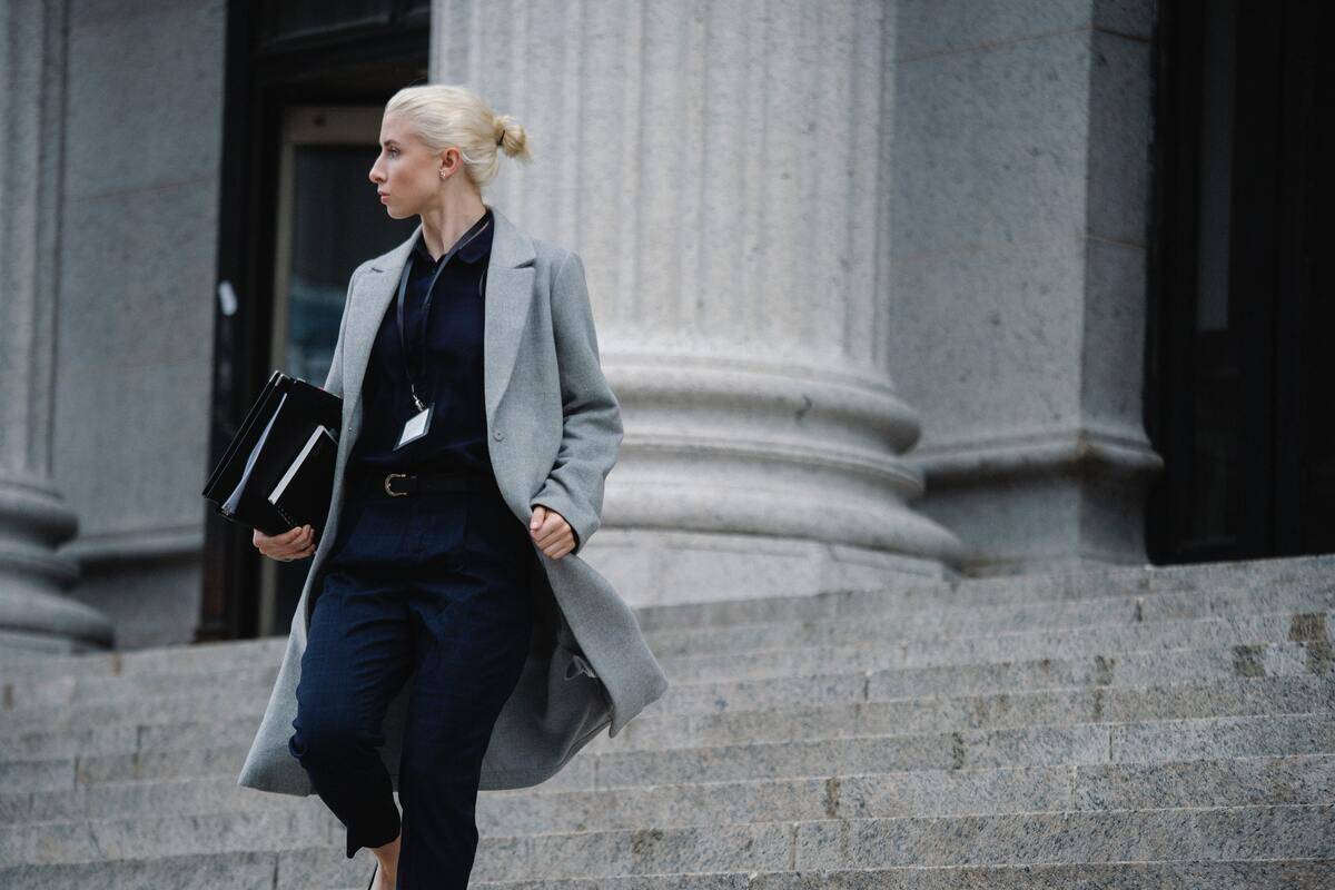 A business woman walking down a set of large stone steps.