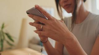 A woman holding and looking at a smartphone.