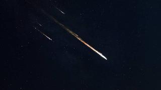 A bright meteor visibly flying across the sky.