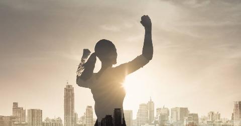 Silhouette of a woman flanked by the city skyline.