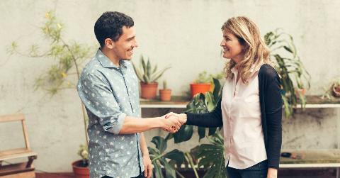 A man and a woman shaking hands, presumably meeting for the first time.