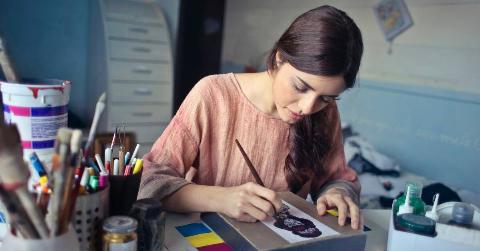 A woman sat at her work desk, drawing something.