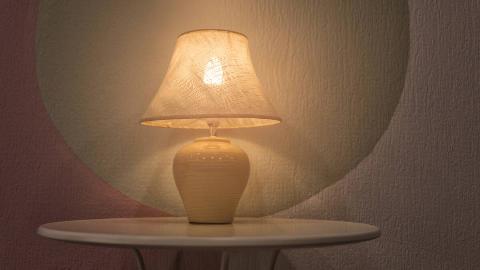 A small white lamp against a colorful wall.