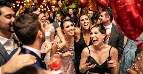 A group of people smiling and having fun in the midst of a busy party.