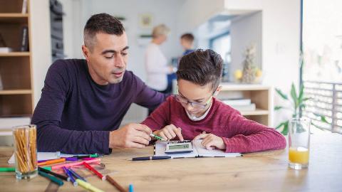 A dad helping his son with math homework.