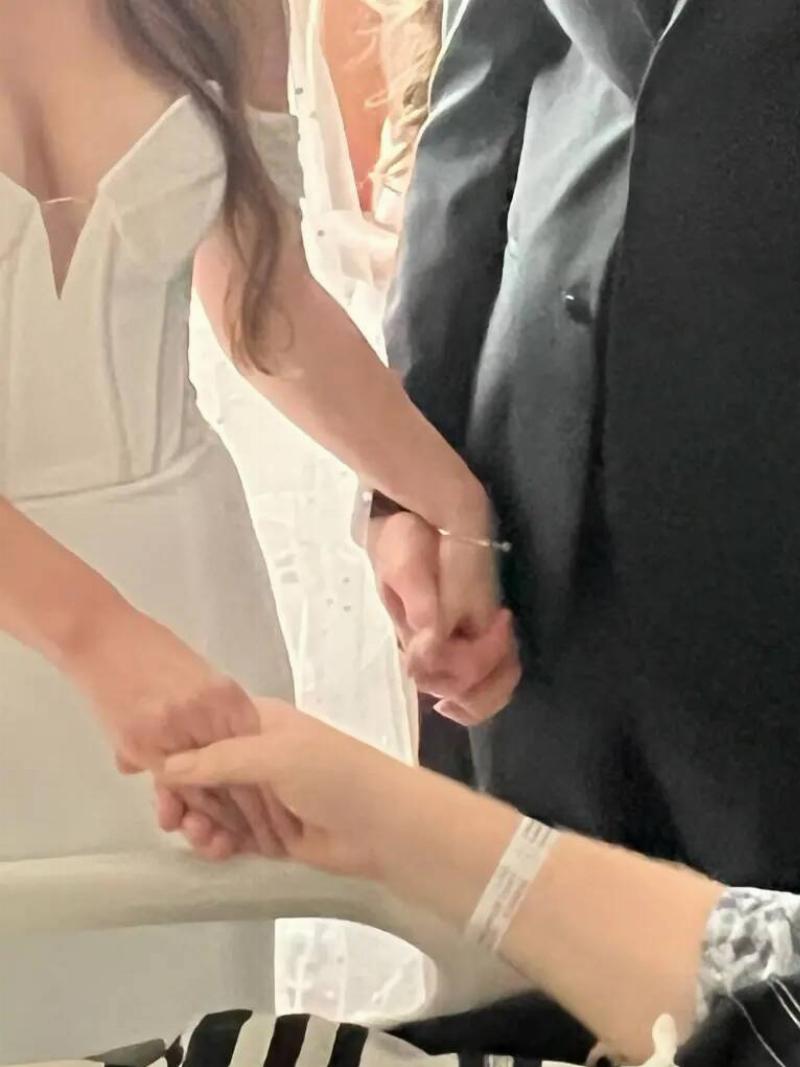 A close shot of Elisabeth holding hands with both her husband and her father during the ceremony.