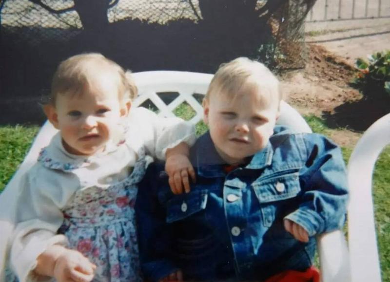 Baby Jack and Bronwyn as toddlers in the 90s, sitting in a chair together.