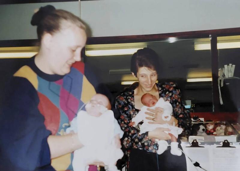 Jack's mom holding him and Bronwyn's mom holding her while they were both still being treated at the hospital.