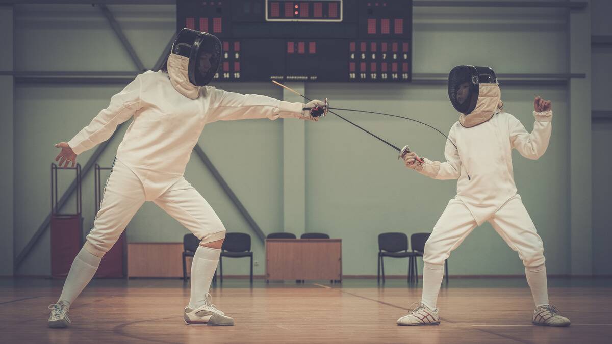 Two people fencing, one person being stuck with the other person's sword.