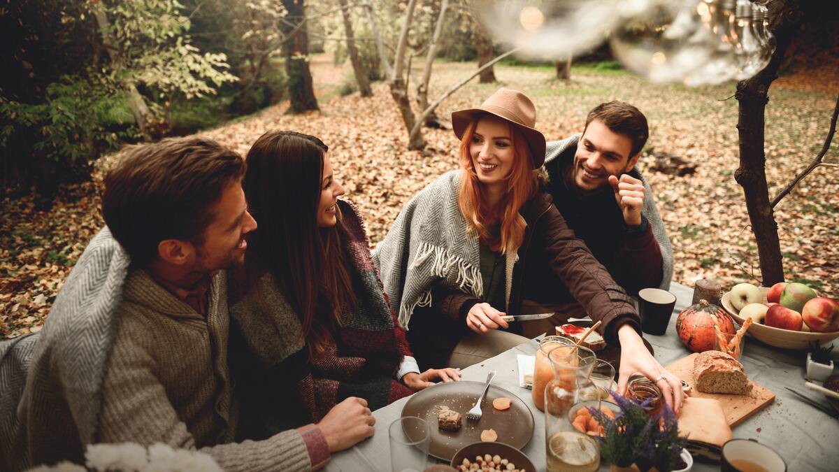 A group of friends sat around a table outdoors, sharing a meal.