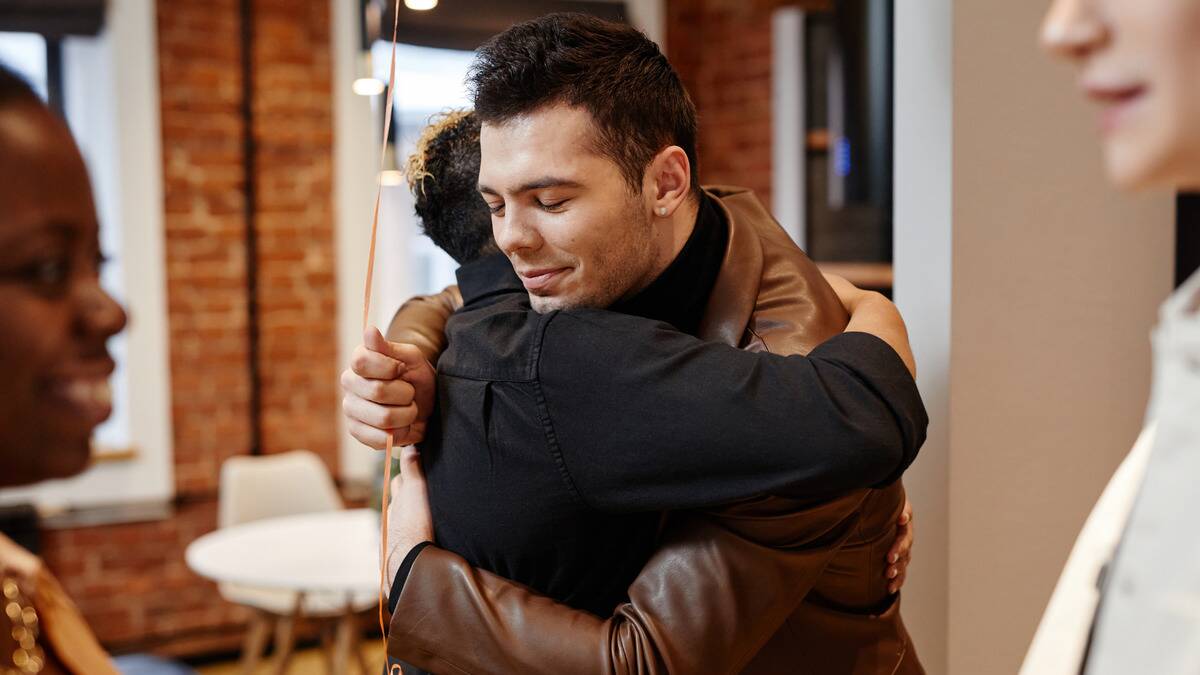 Two friends hugging peacefully, one holding a balloon.