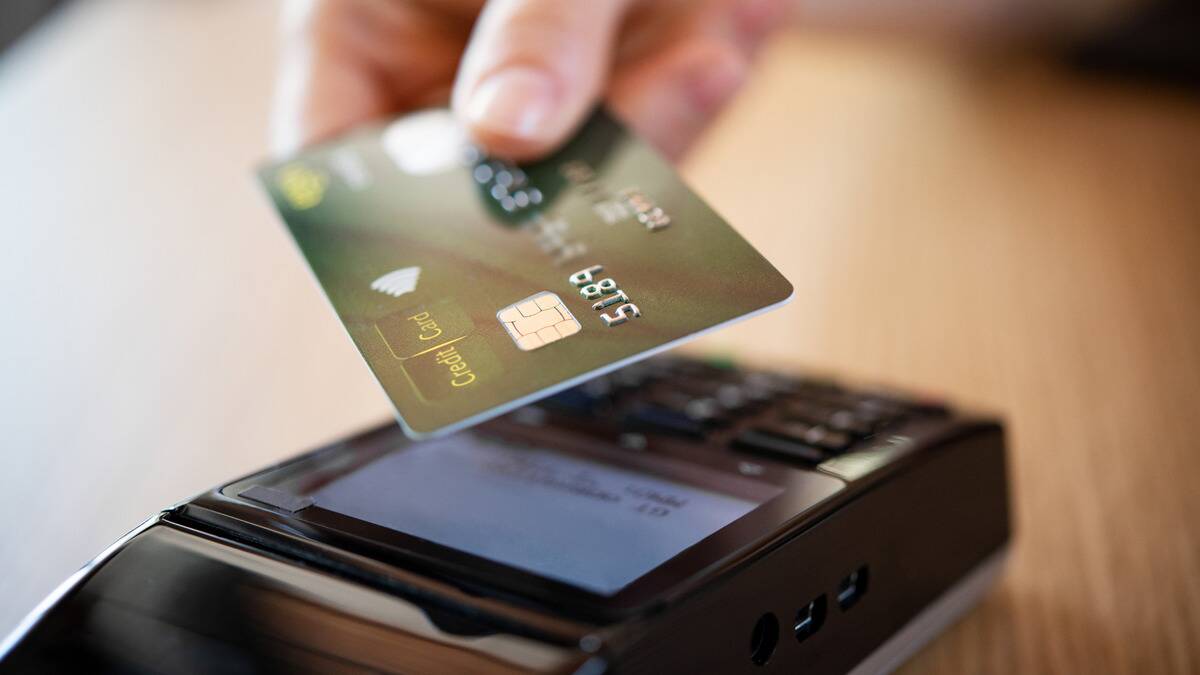 A closeup shot of someone tapping their credit card to pay for something.