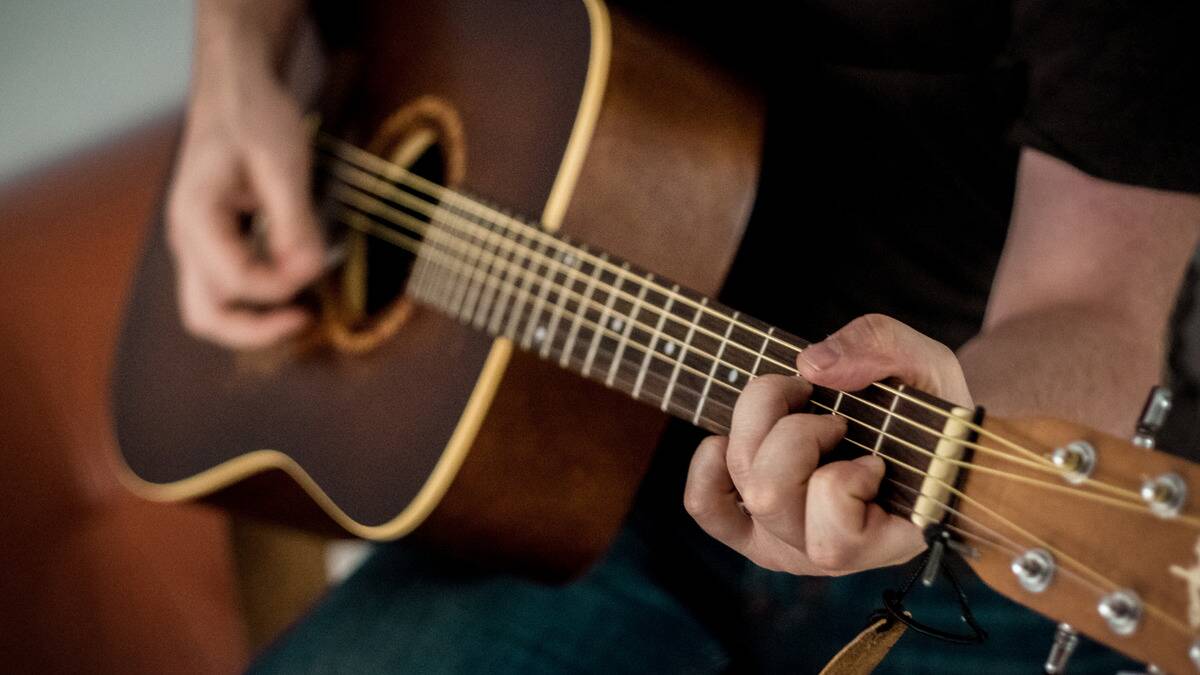 A close shot of someone playing the guitar.