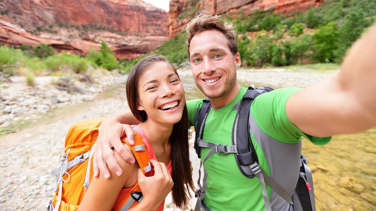 A couple taking a selfie while hiking.