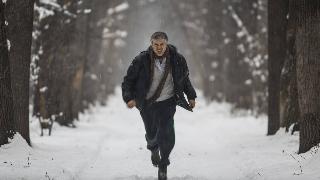 A man running toward the camera in the snow.