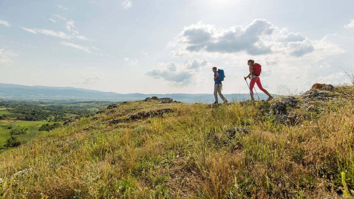 Two friends hiking through a hill range.