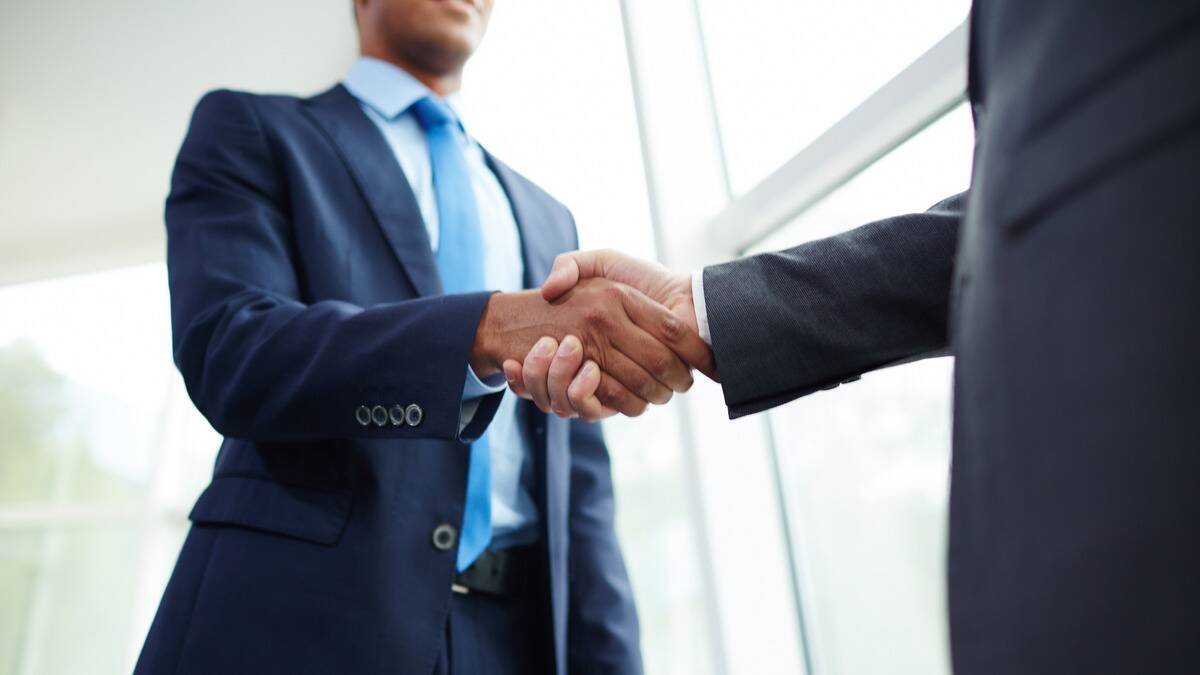 A low angle shot of two businessmen shaking hands.