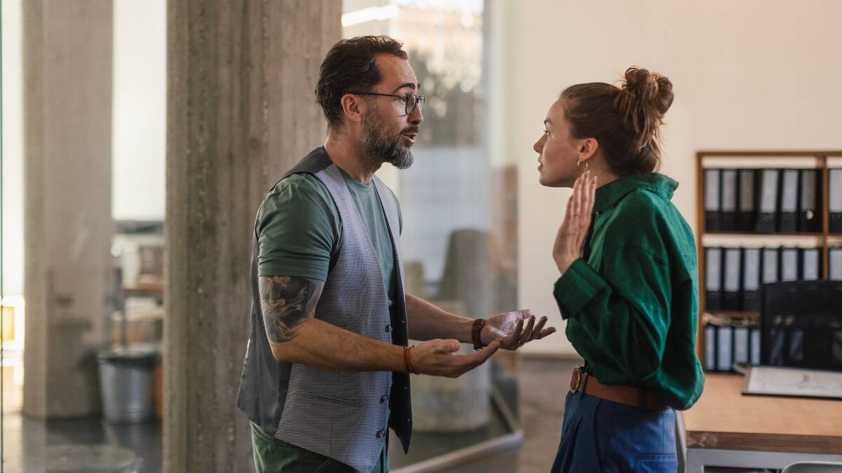 A couple having an argument, both looking stressed and upset as they speak.