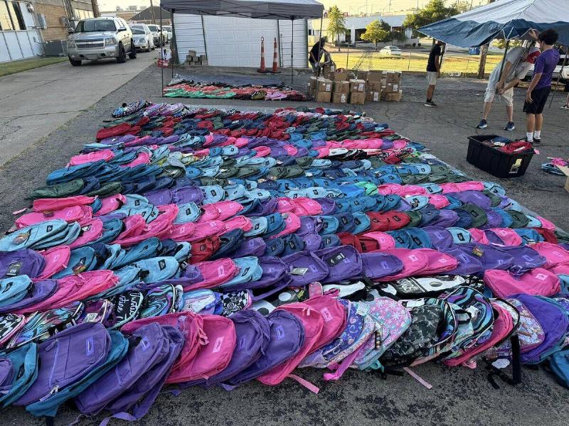 Many of the backpacks they gave out laid out on the ground, ready to be distributed.