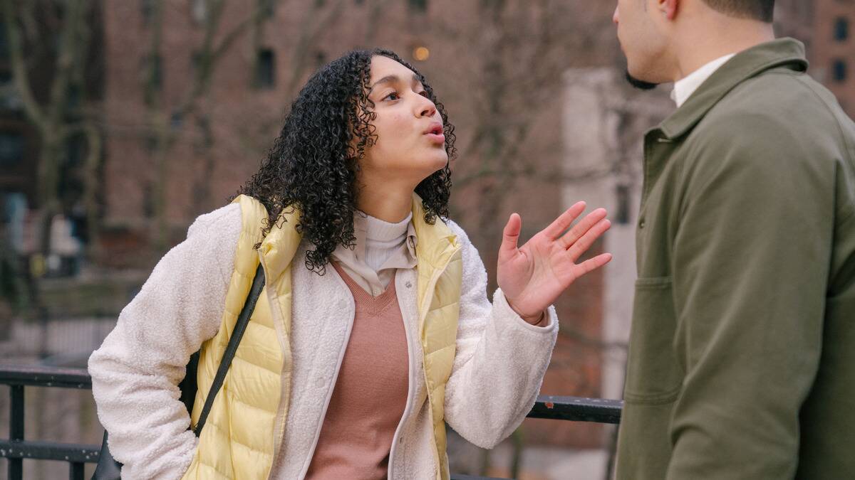 A woman speaking to her boyfriend very pointedly, looking annoyed.