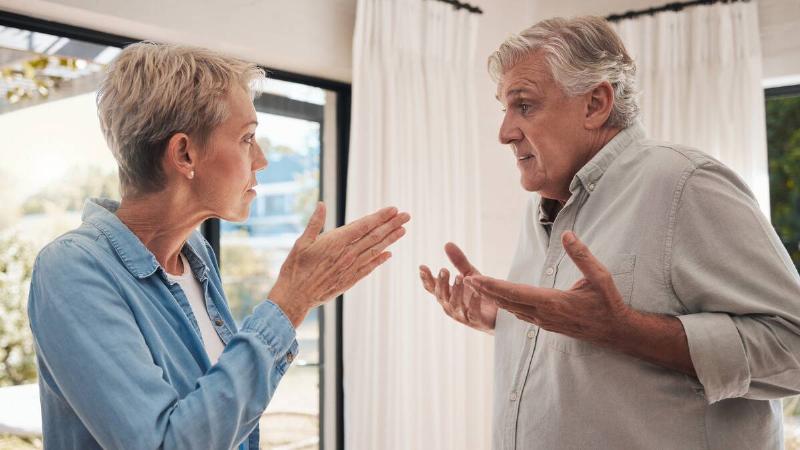 A couple standing close to one another, seemingly having an argument.