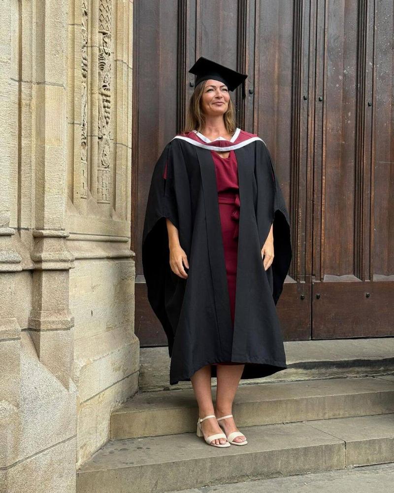 Dr. Bradford standing outside her university for one of her graduation photos.