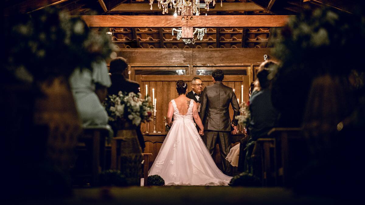 A photo down the aisle of a wedding as the couple is getting married.