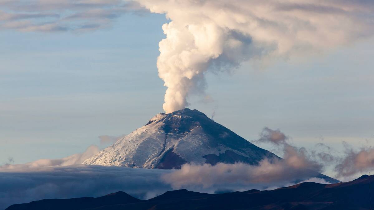 A volcano with smoke pouring out of the top.