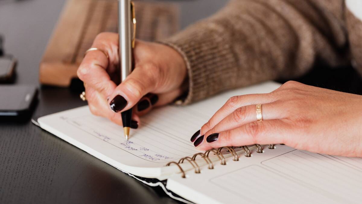 A close shot of someone writing in a journal.