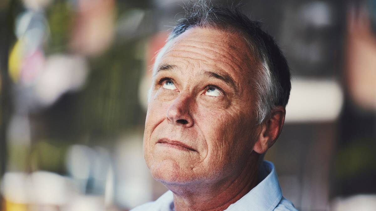 A close shot of a man looking directly upward with just his eyes.