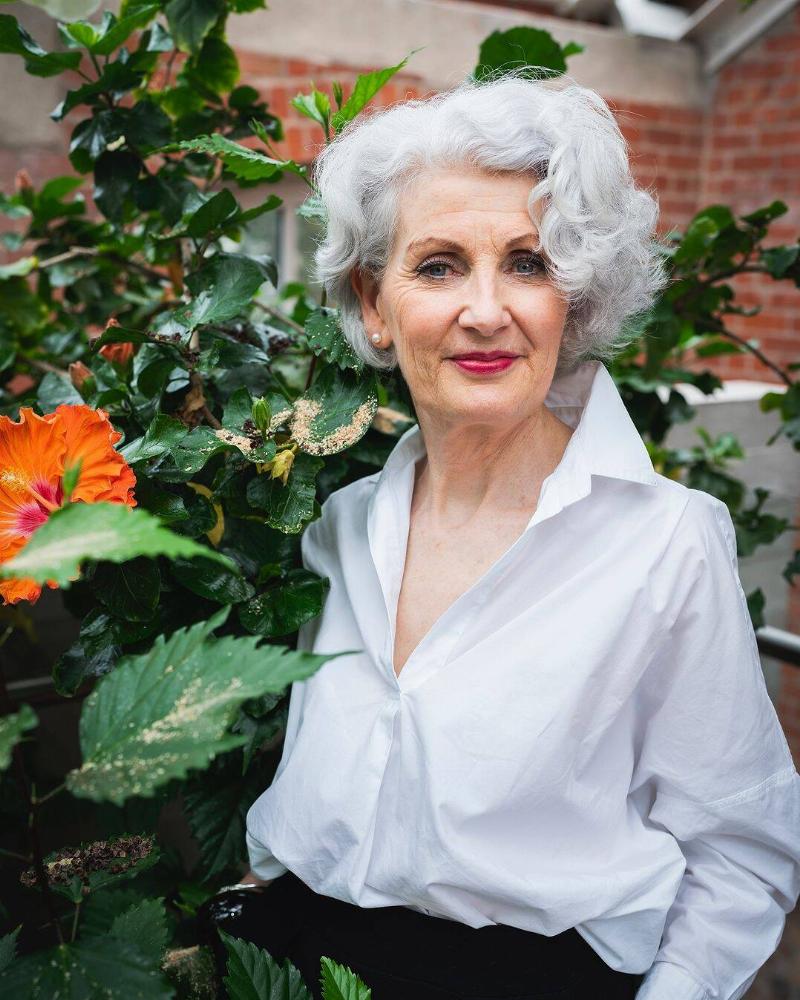 Anne standing in front of some greenery, smiling confidently at the camera.