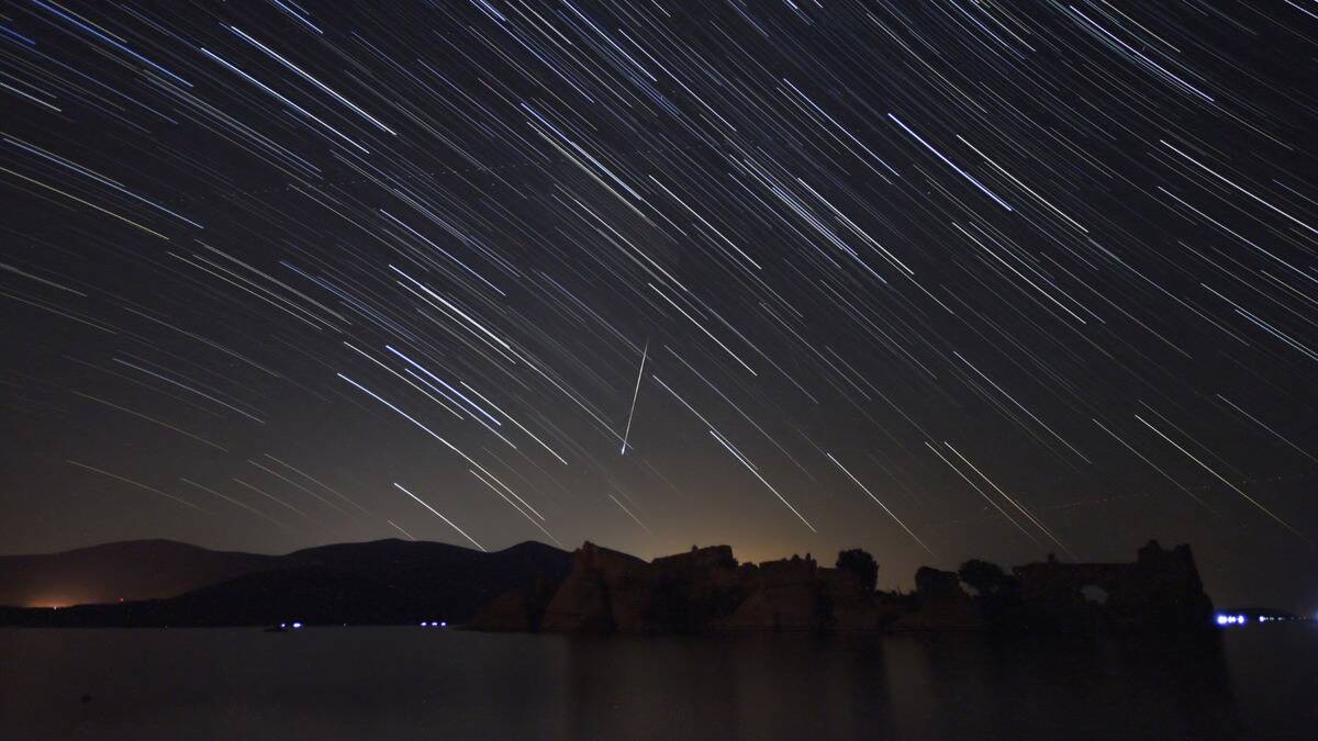 A timelapse photo of stars and meteors moving through the sky.