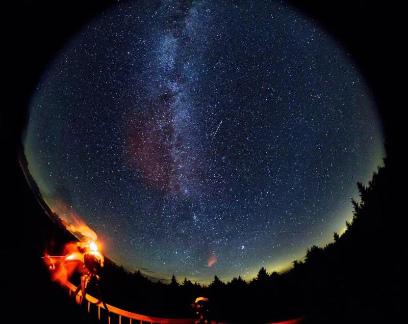 In this 30 second exposure taken with a circular fish-eye lens, a meteor streaks across the sky during the annual Perseid meteor shower as a photographer wipes moisture from the camera lenses Friday, August 12, 2016 in Spruce Knob, West Virginia.