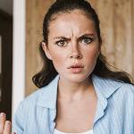 A woman looking at the camera angrily, hands gesturing as she talks.