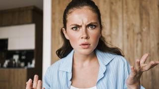 A woman looking at the camera angrily, hands gesturing as she talks.