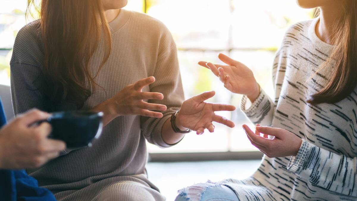 A close shot of two peoples' hands as they chat, both gesturing emotively.