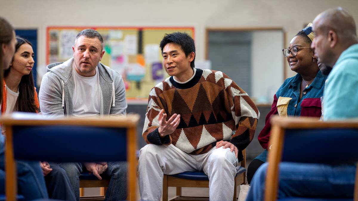 A man speaking to a group of people at a support group.